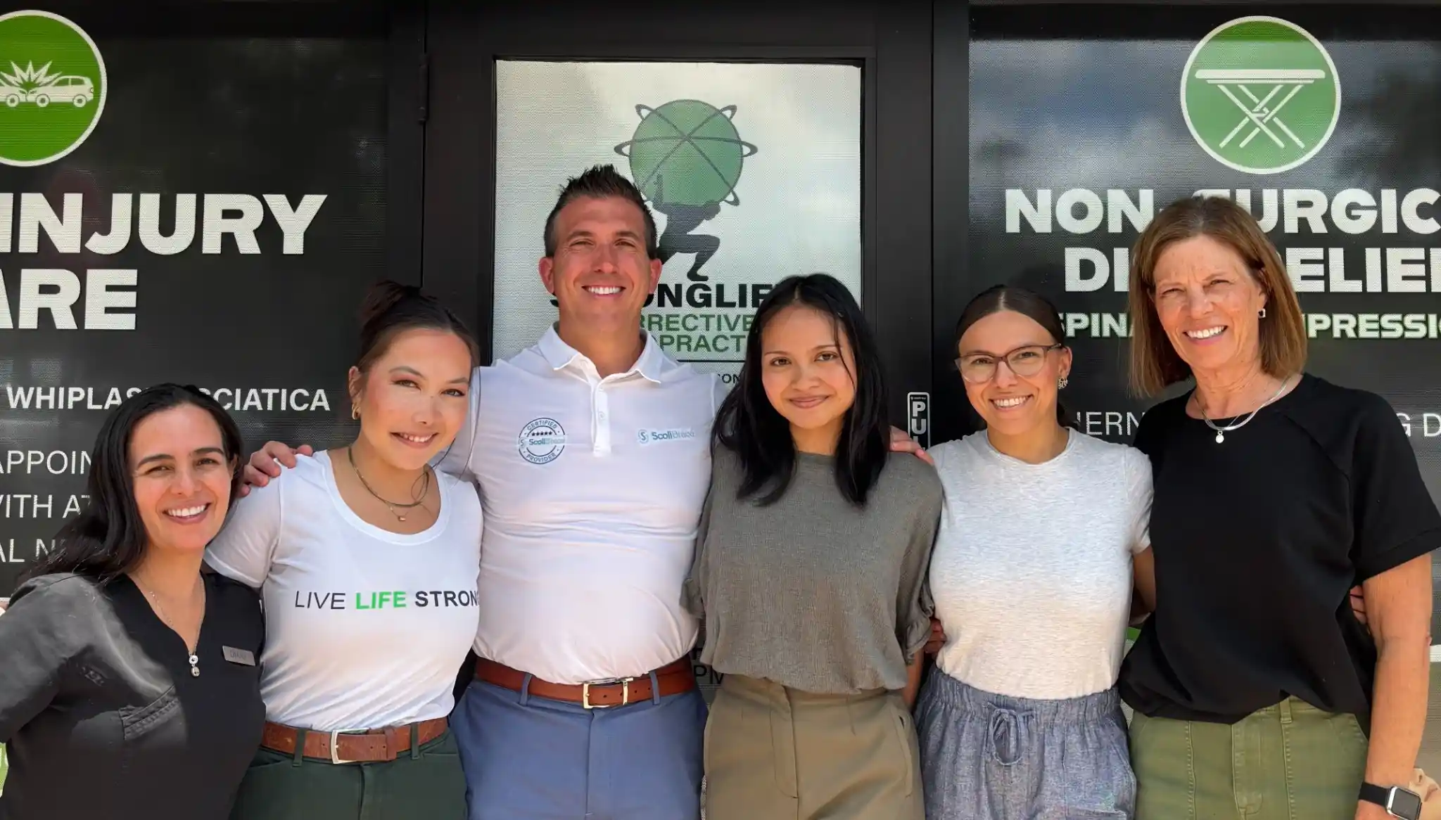 Chiropractic team standing together outside the clinic entrance